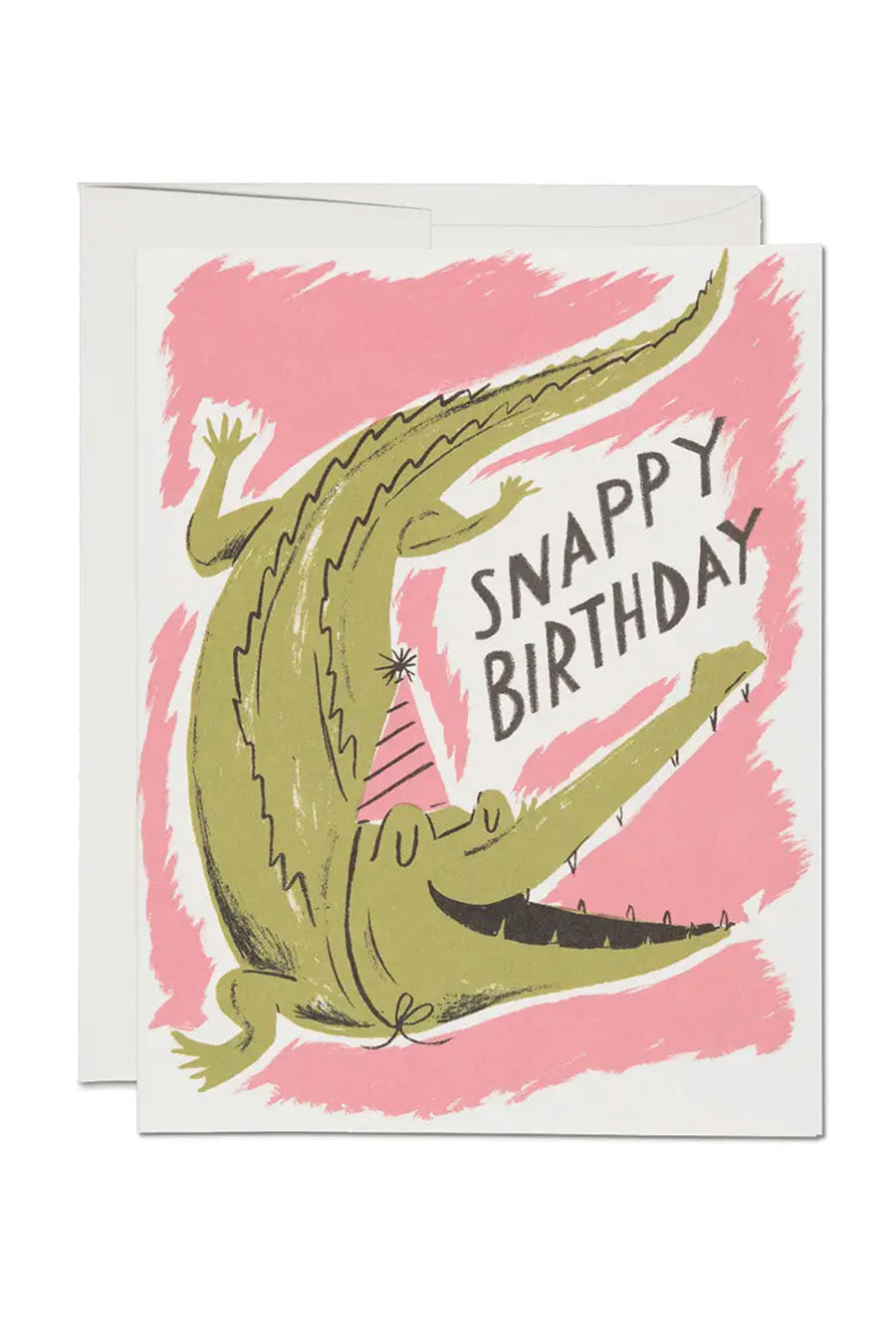 White birthday card of a green alligator in a pink birthday hat. The card says Snappy Birthday against a squiggly pink background. White background.