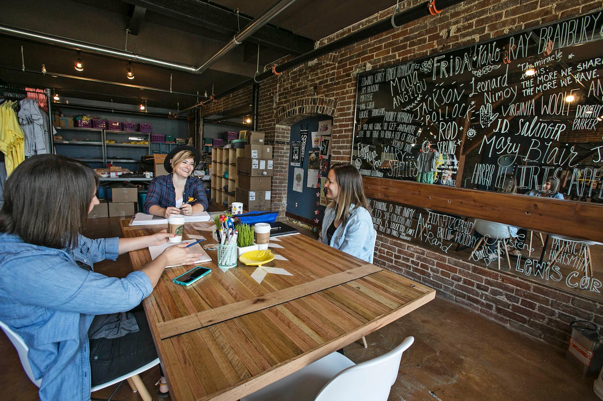 Brittany, Summer, And Kendra sitting around a table brainstorming