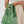 Load image into Gallery viewer, A person holding a Small reusable shopping bag that features an all over print of a photograph of grass. White background.