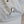 Load image into Gallery viewer, Enamel pin of a white cat bathing itself pinned to a light denim hat.