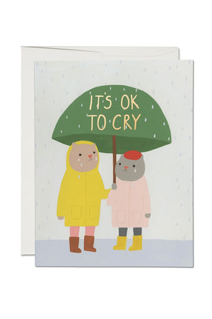 Greeting card of two cats under a green umbrella. The card says It's Ok to Cry.