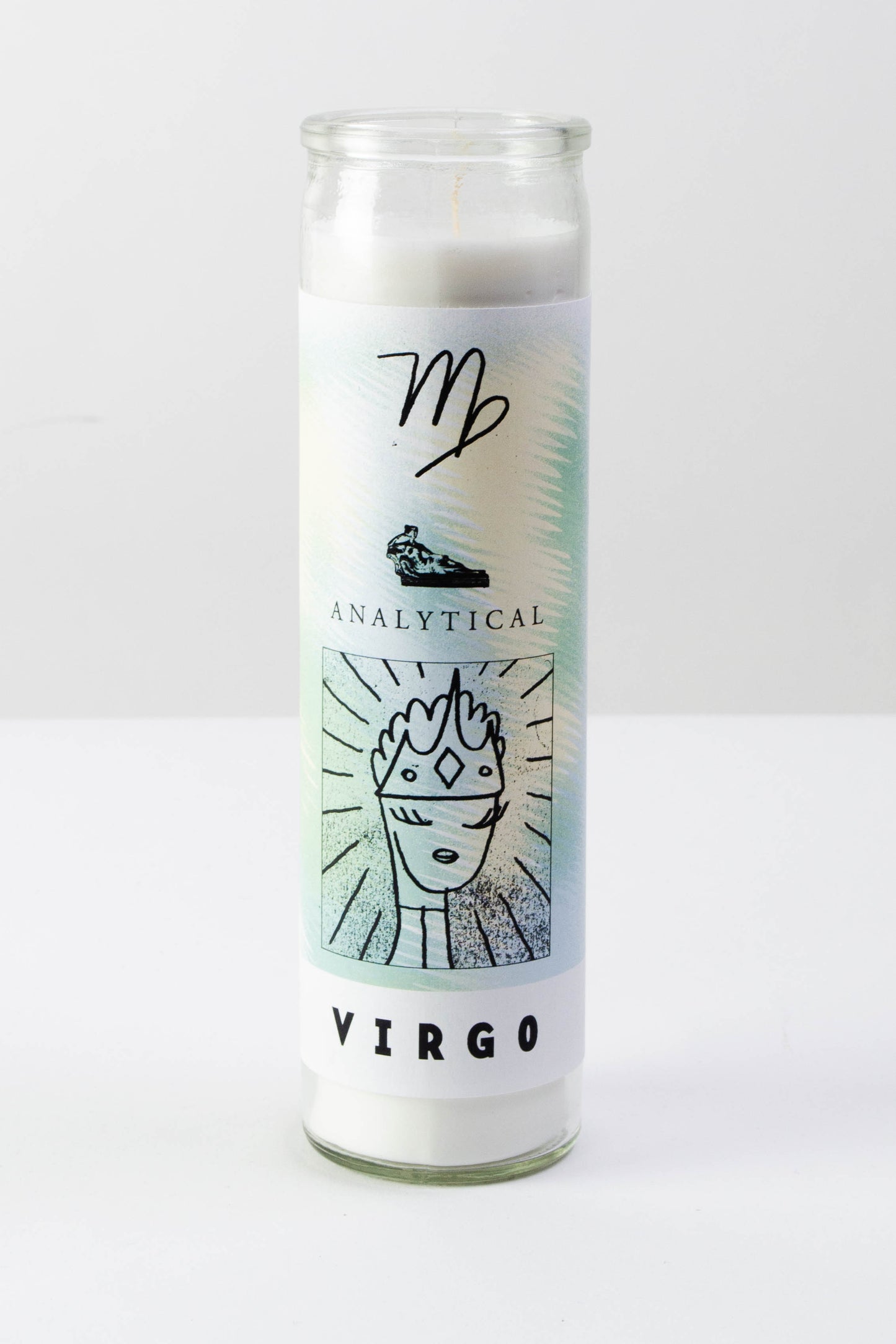 A tall clear glass votive candle with a white, light green, and light yellow decal featuring illustrated symbols about the astrological sign "Virgo" - the text reads "analytical" and "Virgo" in black ink.