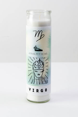 A tall clear glass votive candle with a white, light green, and light yellow decal featuring illustrated symbols about the astrological sign "Virgo" - the text reads "analytical" and "Virgo" in black ink. 