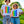 Load image into Gallery viewer, Two people are standing next to a green lawn and sidewalk on a sunny day with large trees behind them. They&#39;re both wearing jeans and white t-shirts with a rectangular vertical rainbow and small white illustrated rainbows.
