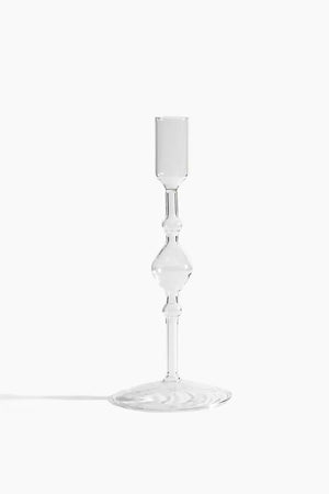 Clear glass votive candle holder on a white background. 
