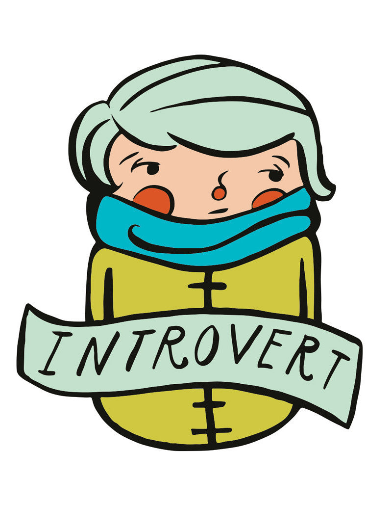 A die-cut sticker of an illustrated whimsical person in a mustard yellow overcoat and teal scarf with rosy cheeks. Across their chest is a banner that reads "Introvert."
