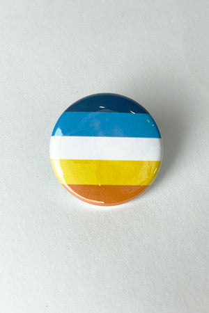 A pinback button featuring the colors of the Aroace flag.