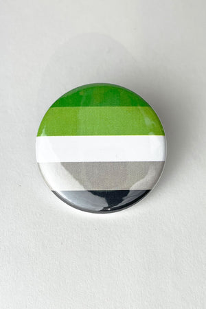 A pinback button featuring the colors of the Aromantic pride flag.