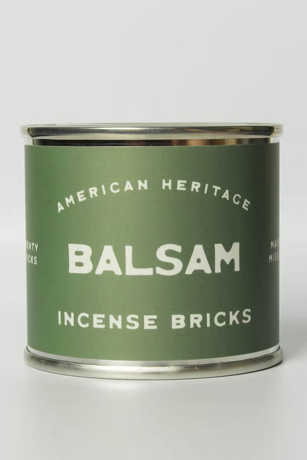 Tin container with a green label that says American Heritage Incense Bricks Balsam. White background.