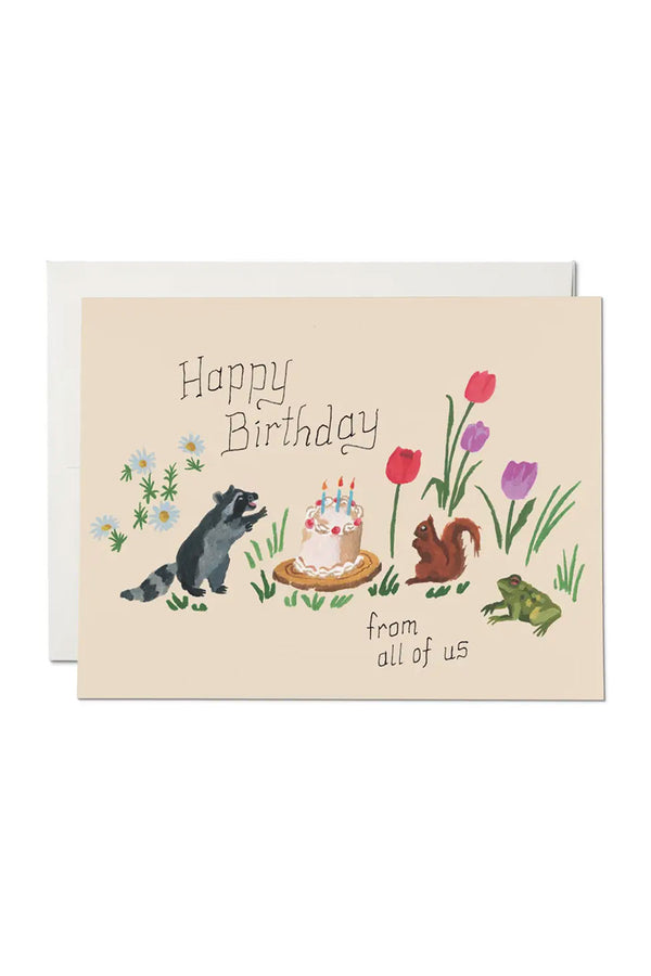 Greeting card of a raccoon, squirrel, and a frog surrounding a birthday cake. Card Says Happy Birthday from all of us.