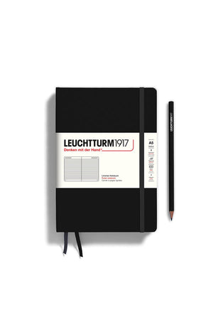 Black hardcover notebook with ruled pages. Two ribbon page markers and an elastic strap to keep the book secured when closed. White background. Pencil not included. 