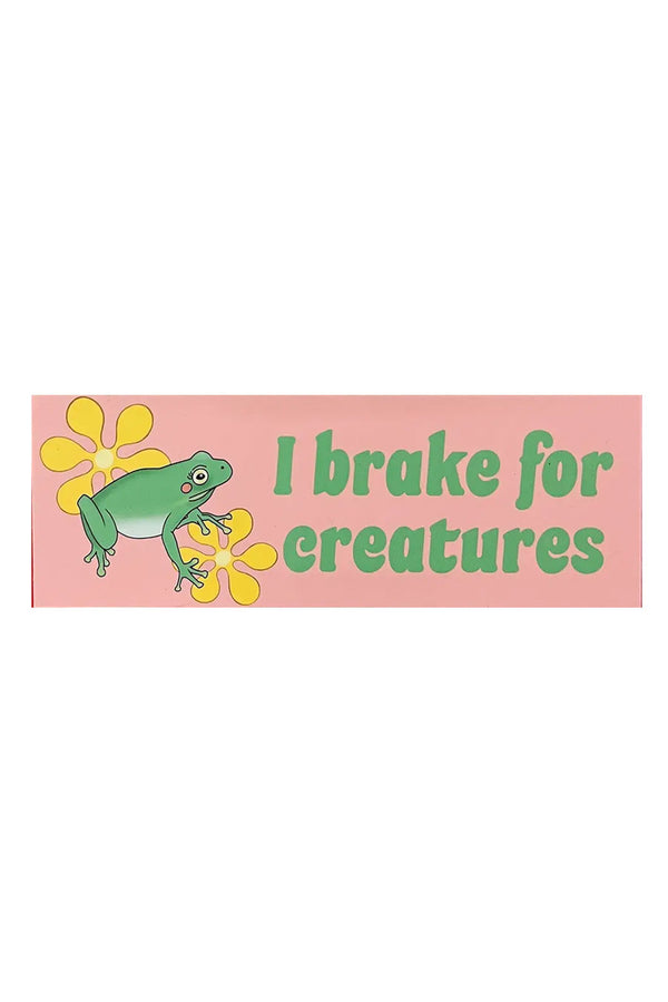 Pink car magnet that says I brake for creatures and features a green frog and yellow flowers. White background.