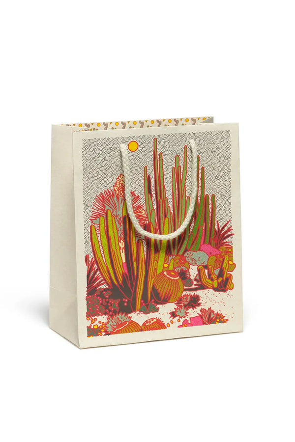 Gift bag with a desert scene of various green and pink cacti under a sun.