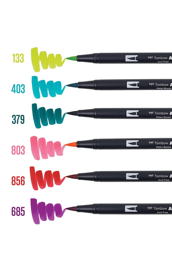 Set of 6 Dual Brush Pen colors. Flexible brush tip and fine tip in one marker. Colors Included: Chartreuse, Bright Blue, Jade Green, Pink Punch, Poppy Red, and Deep Magenta. Markers are next to an example of the brush tip of the markers.
