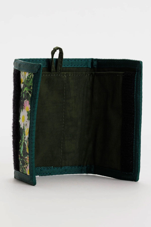 Interior of tri-fold velcro nylon wallet. The wallet features a key loop and the outside design is of daisies in grass all over. White background.