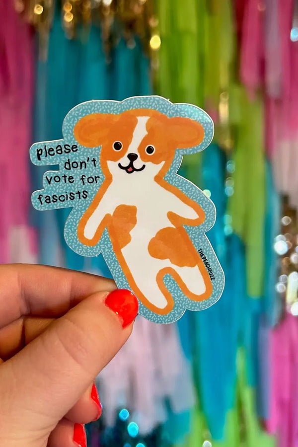 Die cut sticker of a white and tan dog. Sticker says Please don't vote for fascists.