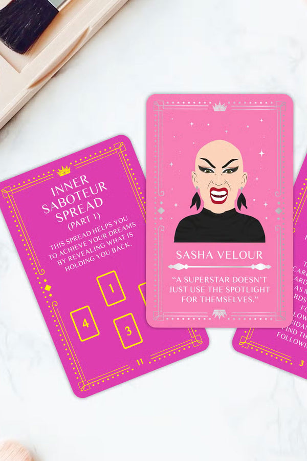Three pink Drag Queen Oracle deck cards. Once card features Shasha Velour and it says " A Superstar doesn't just use the spotlight for themselves."