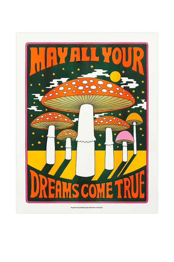 Risograph print of Red mushrooms under a dark sky filled with white clouds and a yellow moon. The print says May all Your Dreams Come True. The image is surrounded by a thin pink border. White background.