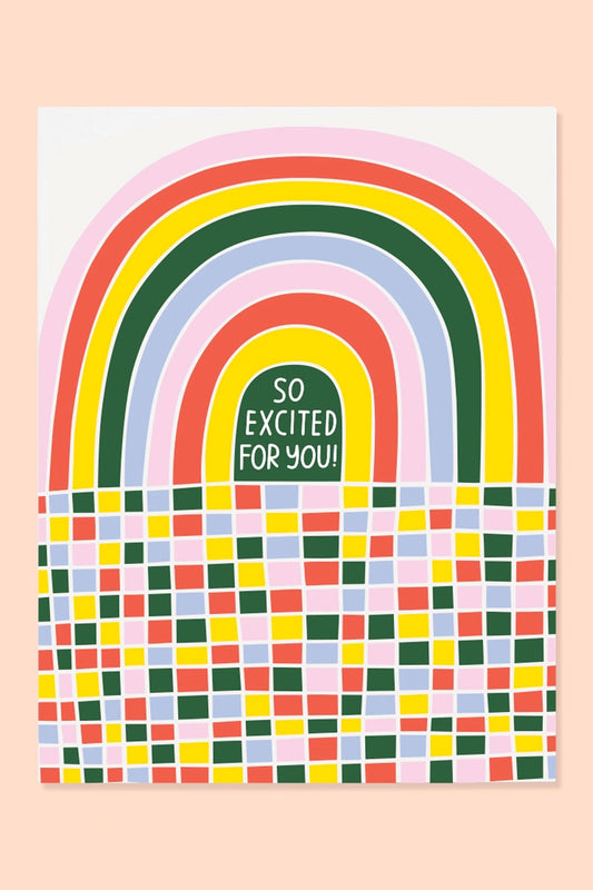 Greeting card of a red, pink, yellow, and green rainbow. Below the rainbow is multicolor squares of the same colors as the rainbow. The card says So Excited For You!