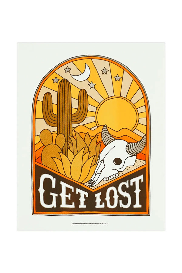 Risograph print of an Arch shape with a cow skull next to desert plants and a cactus under a beaming sunset with a moon and stars in the sky. Under the skull the print says Get Lost.  White background.