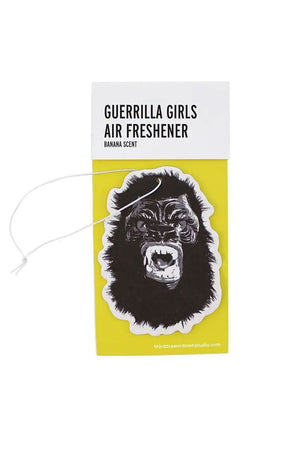 Air Freshener of a Gorilla face against a yellow card backing. The top of the backing says Guerrilla Girls Air Freshener, Banana Scent. White background.