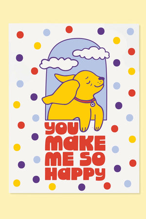 Greeting card covered in purple, yellow, red, and baby blue dots. In the middle of the card, there is a yellow dog looking out a window. Below the dog in red block letters the cards says You Make Me So Happy.