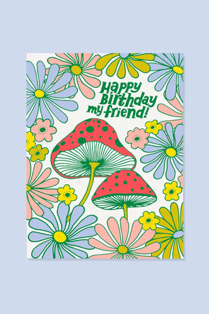 Greeting card featuring two red cap mushrooms surrounded by blue,pink, yellow, and green flowers. Card says Happy Birthday My Friend!