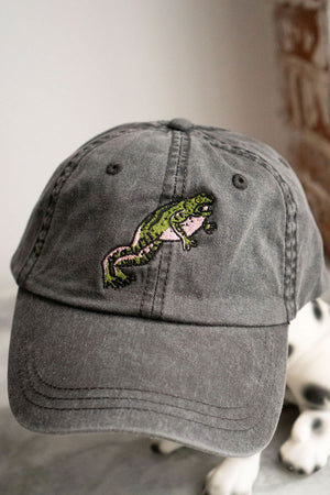Gray denim baseball hat featuring a green and pink jumping frog.