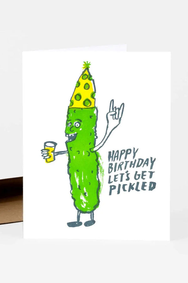 Greeting card of a pickle with a birthday hat holding a drink. Card says Happy Birthday Lets Get Pickled.