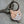 Load image into Gallery viewer, Soft enamel keychain with copper hardware. The keychain features a portrait of a cat with scowling face. The cats collar says Lil&#39; Shit. Concrete background.
