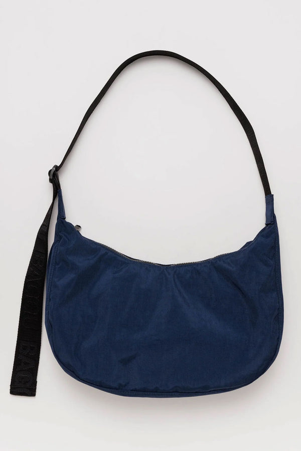 Navy crescent shaped crossbody bag with black straps.