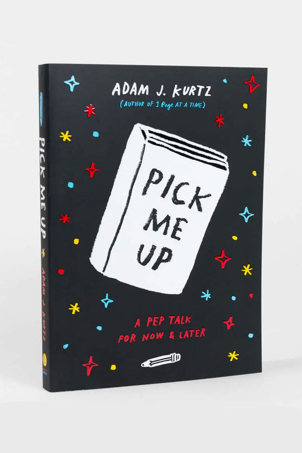 Paperback book with a black cover features an illustration of a white book with Pick Me Up on the cover. The white book is surrounded by red, blue, and yellow stars and dots. White background. Book by Adam J Kurtz