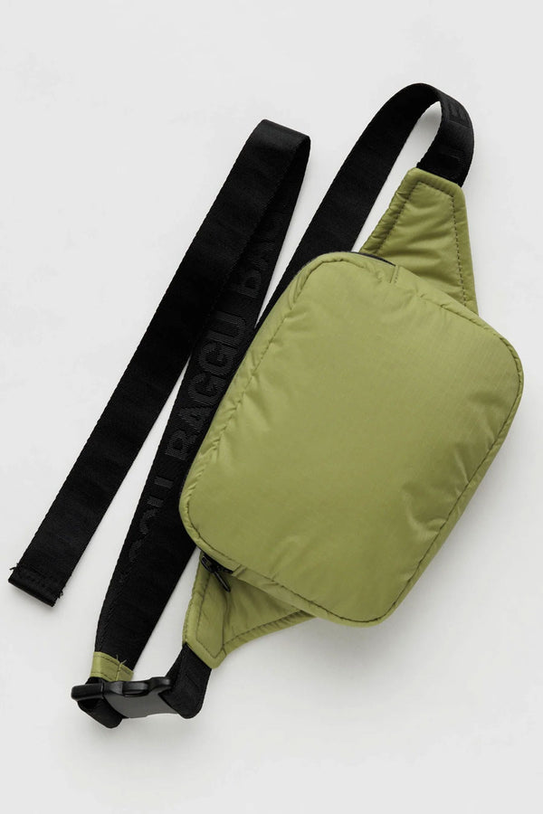 Puffy nylon fanny pack in Pistachio green. The fanny pack has black straps that says Baggu in a repeating pattern. White background.