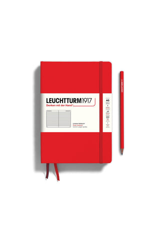 Hardcover Red A5 notebook with ruled pages. Two ribbon page markers and an elastic strap to keep the book secure when closed. Pencil not included. White background.