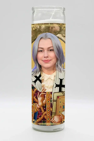 Prayer votive candle with a photo of Phoebe Bridgers depicted as a saint in robes holding a holy text.