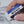 Load image into Gallery viewer, Someone using a Soft plastic eraser with a protective paper sleeve that features blue white and black stripes. The sleeve says Plastic eraser. Mono. Tombow. 
