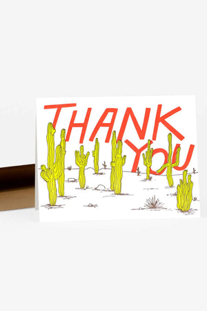 Greeting card That says Thank You in red lettering behind a desert landscape of cacti.