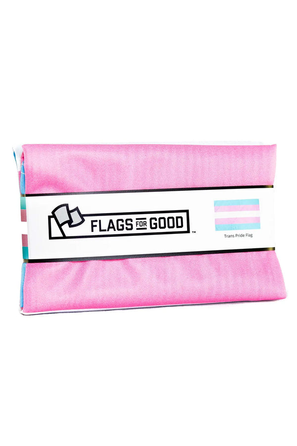 Folded Transgender Pride Flag against a white background. The flag is bound by a paper band that says Flags for Good across it. 