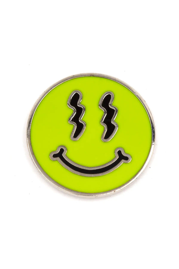 Round bright green smiley face pin with squiggly eyes. White background.