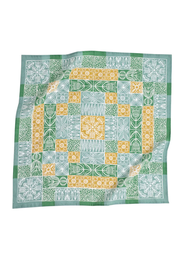 Green and blue quilt pattern bandana with white flowers. White background.