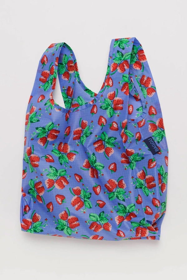 Reusable shopping bag featuring illustrated strawberry clusters against a light periwinkle background. White background.
