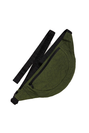 Crescent shape fanny pack in forest green with black straps. white background.