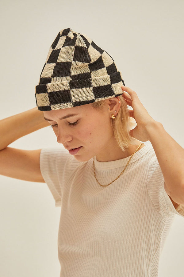 Woman wearing black and white checkerboard beanie