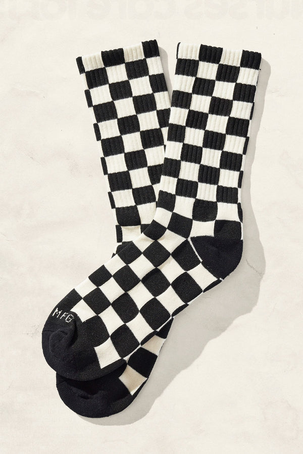 Socks with a black toe and heel covered in a black and cream checkerboard pattern.