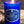 Load image into Gallery viewer, Blue glass candle jar with a raw edge cork top. Candle has a blue label that says Blue Velvet Gin. Natural wood backdrop.
