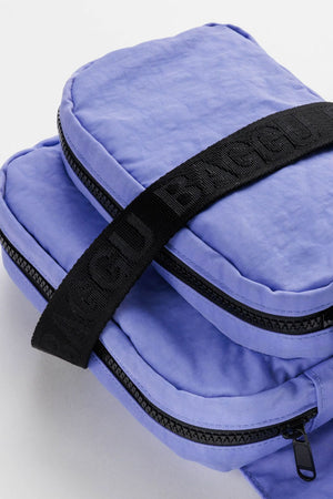 Close up photograph of nylon fanny pack with black straps in light blue. White background.