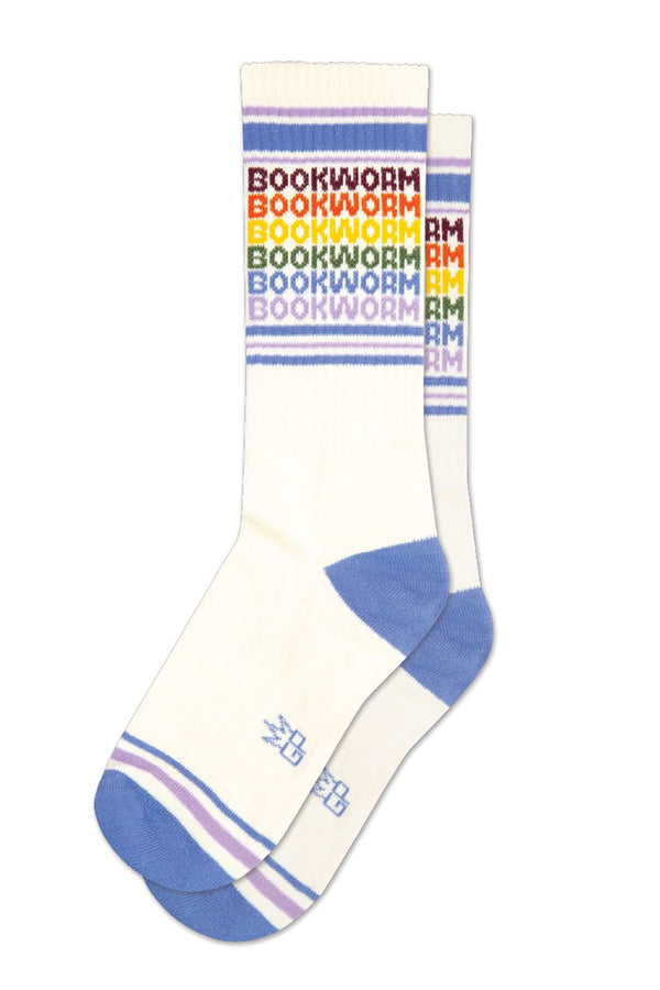 One pair of off white mid calf athletic sock with a blue heel and toe. Across the toes and the top are muted purple and blue stripes. The socks say Bookworm six times. Each one with a different mutes color assigned to it. Top to bottom is Maroon, orange, yellow, green, blue, and purple. White background.