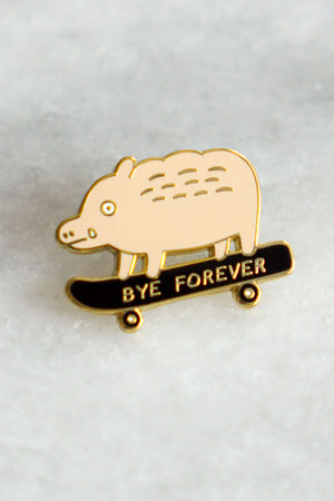 Enamel pin of a light peach boar on a black skateboard. The boar has a small tear from its eye and the skateboard says Bye Forever. White marble background.