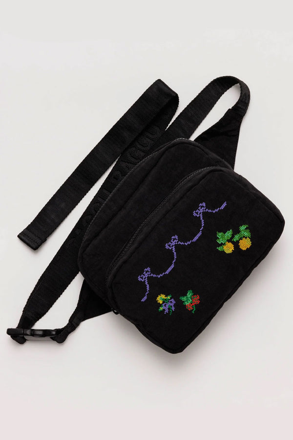 Black fanny pack featuring cross stitch design of purple ribbons, fruits , and flowers.