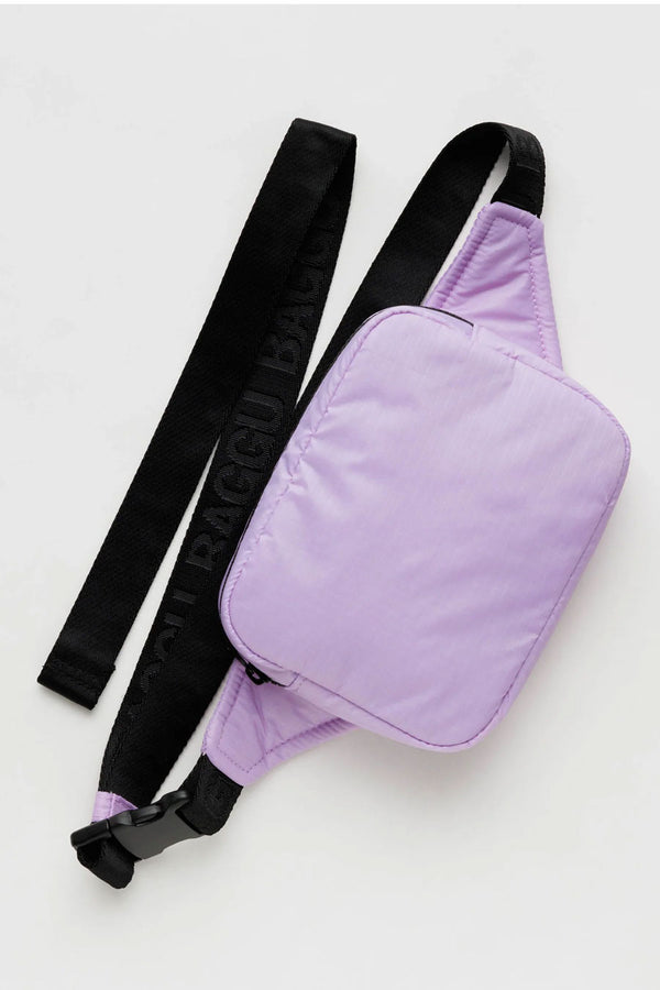 Puffy nylon fanny pack with black straps. The fanny pack is lilac and the black straps say Baggu in a repeating pattern. White background.